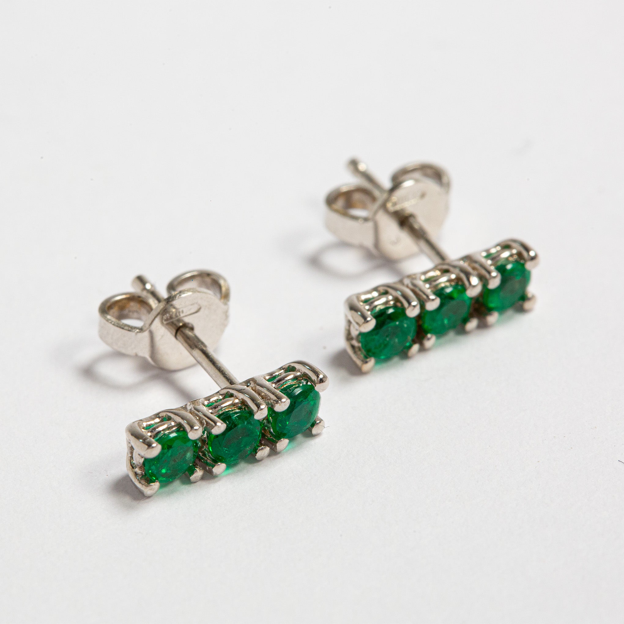 Smeralco's gold earrings with Colombian emeralds, featured at London Finance, radiating sophisticated charm and unparalleled luxury